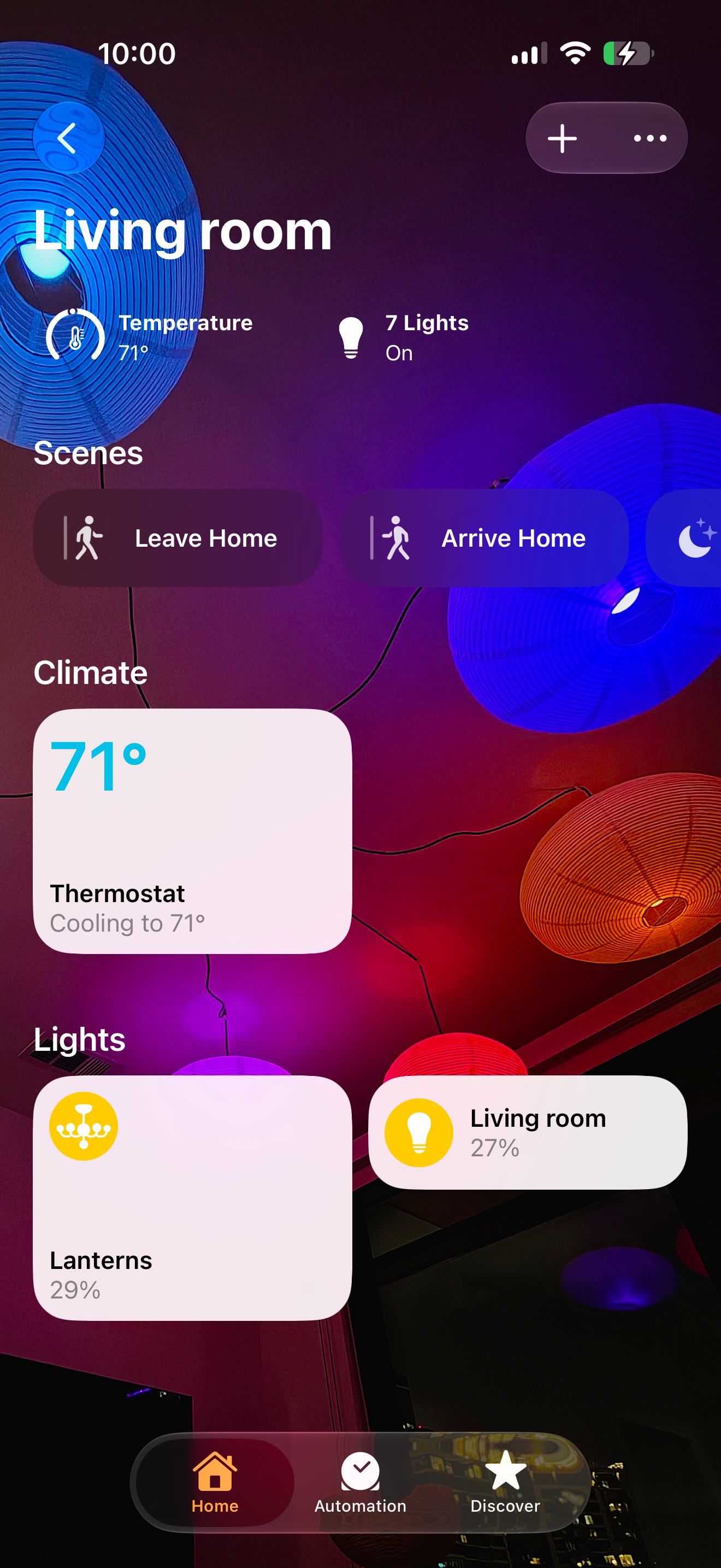 The Home app's Living Room view with a photo of the room's glowing paper lanterns as the background, showing temperature, how many lights are on, Leave and Arrive Home scenes, and brightness sliders for the lanterns.